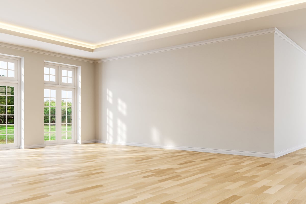 An empty room ready for handover, viewed toward tall windows