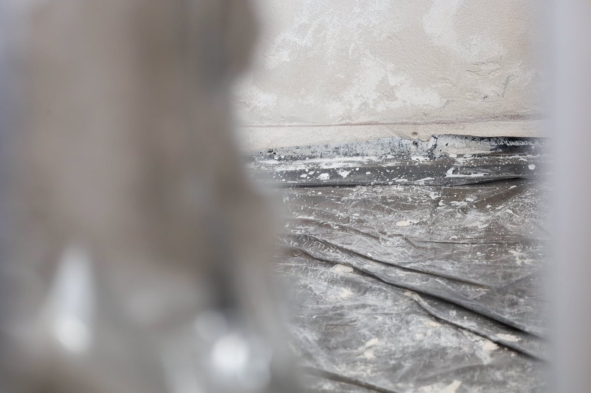 A construction site with protective plastic sheeting covering the floor against debris and dust